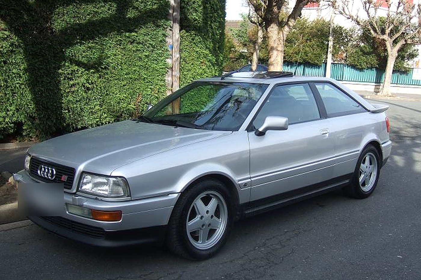 Audi S2 Coupé grise de trois quarts avant, calandre aux anneaux et badge S2, jantes Avus 5 branches