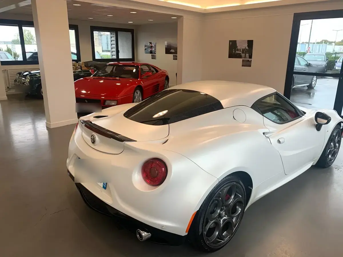 Alfa Romeo 4C blanc mat et Ferrari 348 rouge dans le showroom d'Espace du Maine à Cholet
