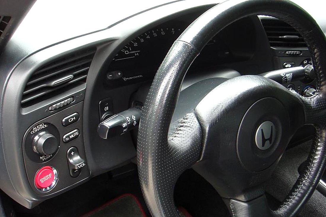 Poste de conduite Honda S2000 : volant, compteur numérique et bouton de démarrage rouge