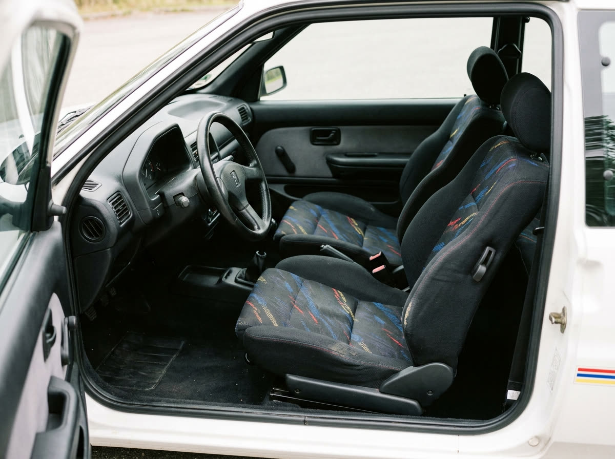 Intérieur Peugeot 106 Rallye : sièges baquets en tissu à motifs, volant trois branches, tableau de bord sobre des années 90