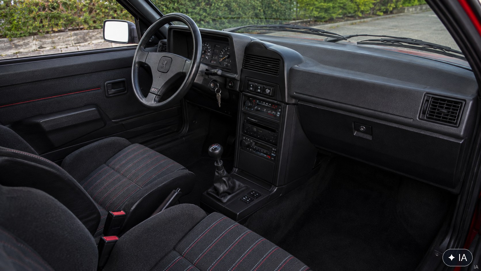 Intérieur Peugeot 309 GTI : sièges sport, volant à trois branches et planche de bord d'époque